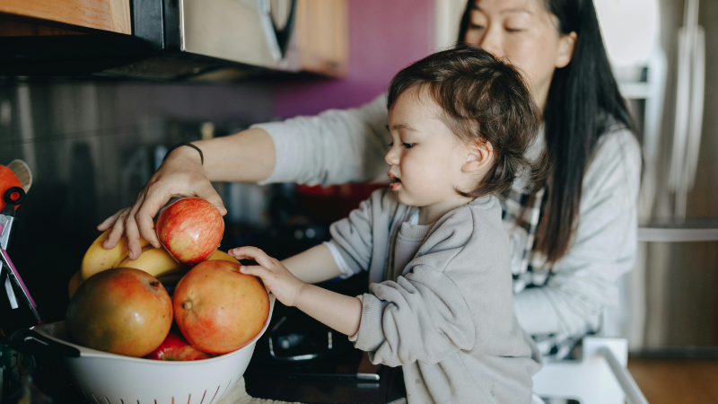 Mãe ajudando o filho a pegar a maça
rotina de limpeza semanal