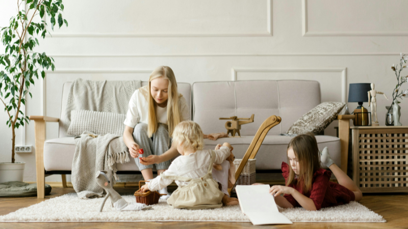 mãe brincando com crianças pequenas em uma casa organizada